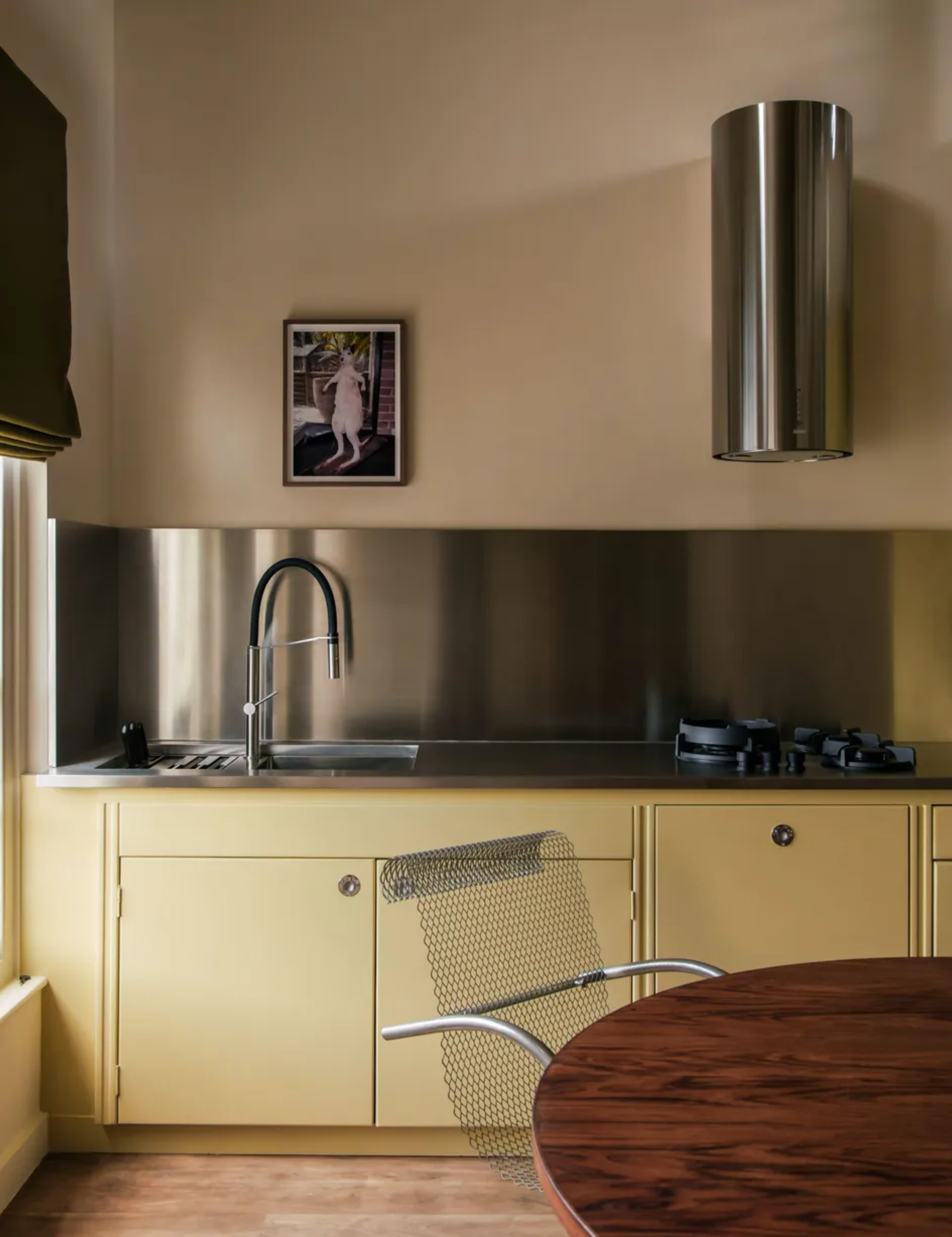 yellow art deco inspired kitchen walls and cabinets with stainless steel countertops and accessories