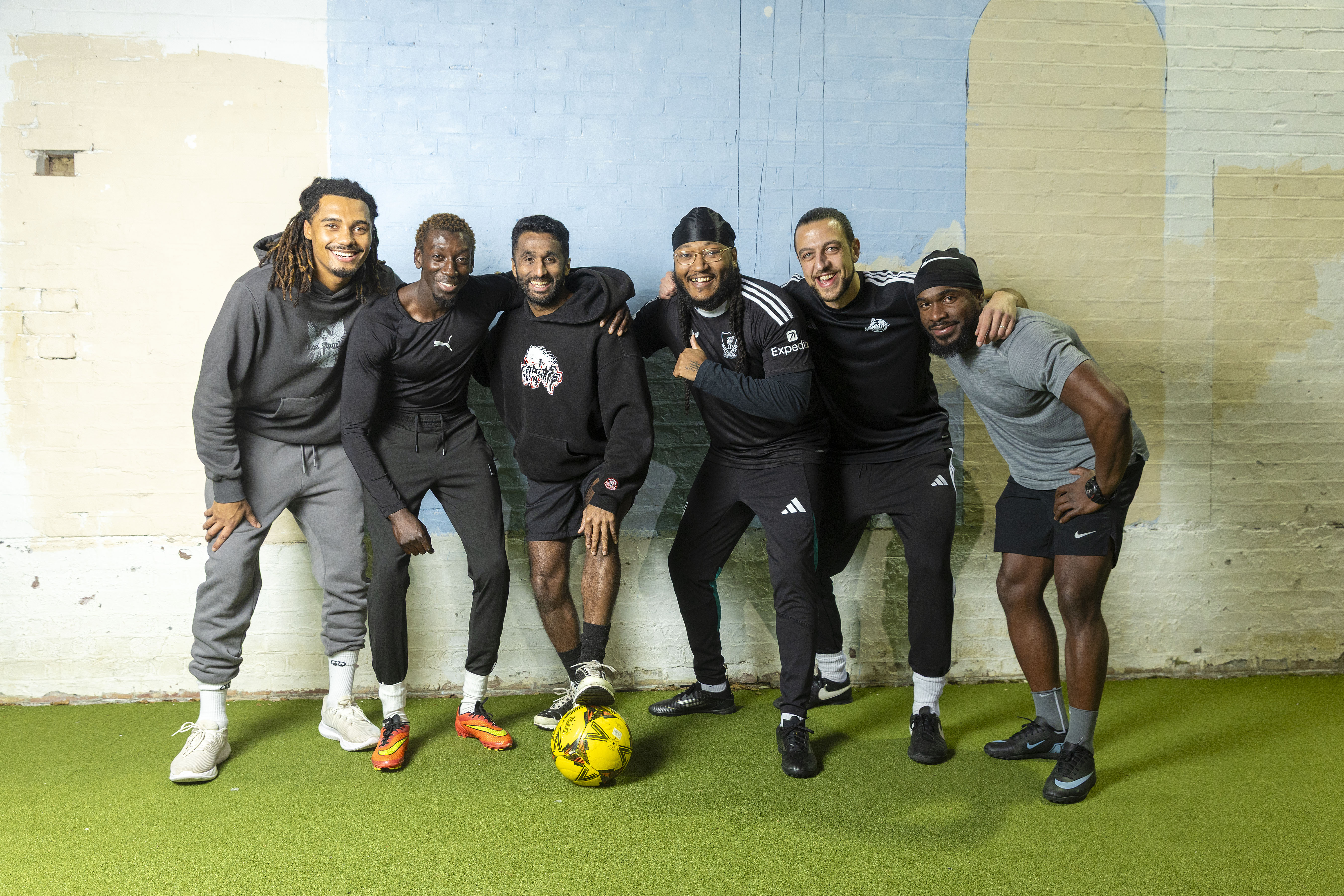 Six men, Ash, Frederick Knight, Rahul Rohit, Tashan Lane-Pierre, Freddie Harding and Kelmoy, pose for a photograph on an indoor football pitch.