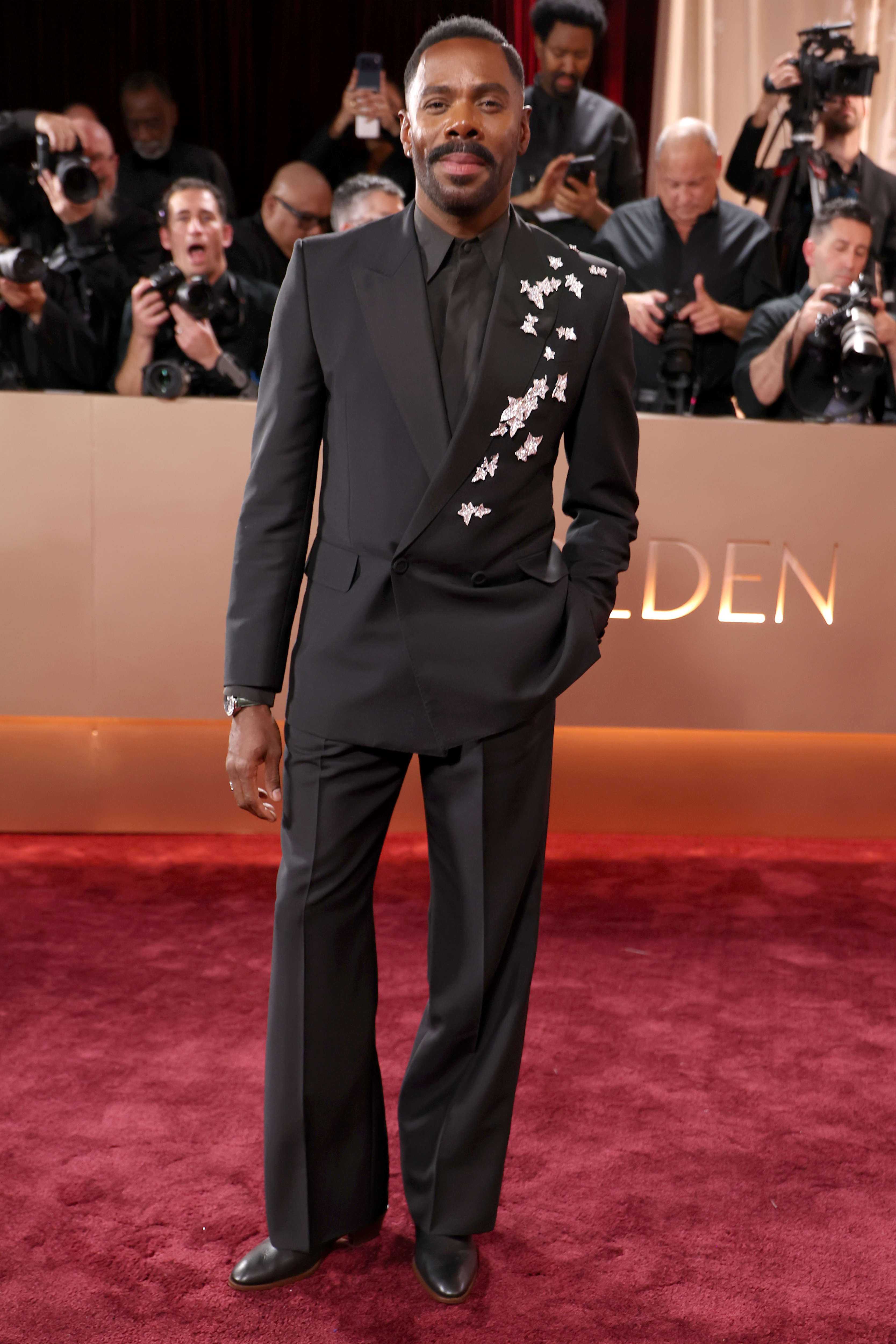 Colman Domingo at the Golden Globe Awards, wearing a black suit with star embellishments.