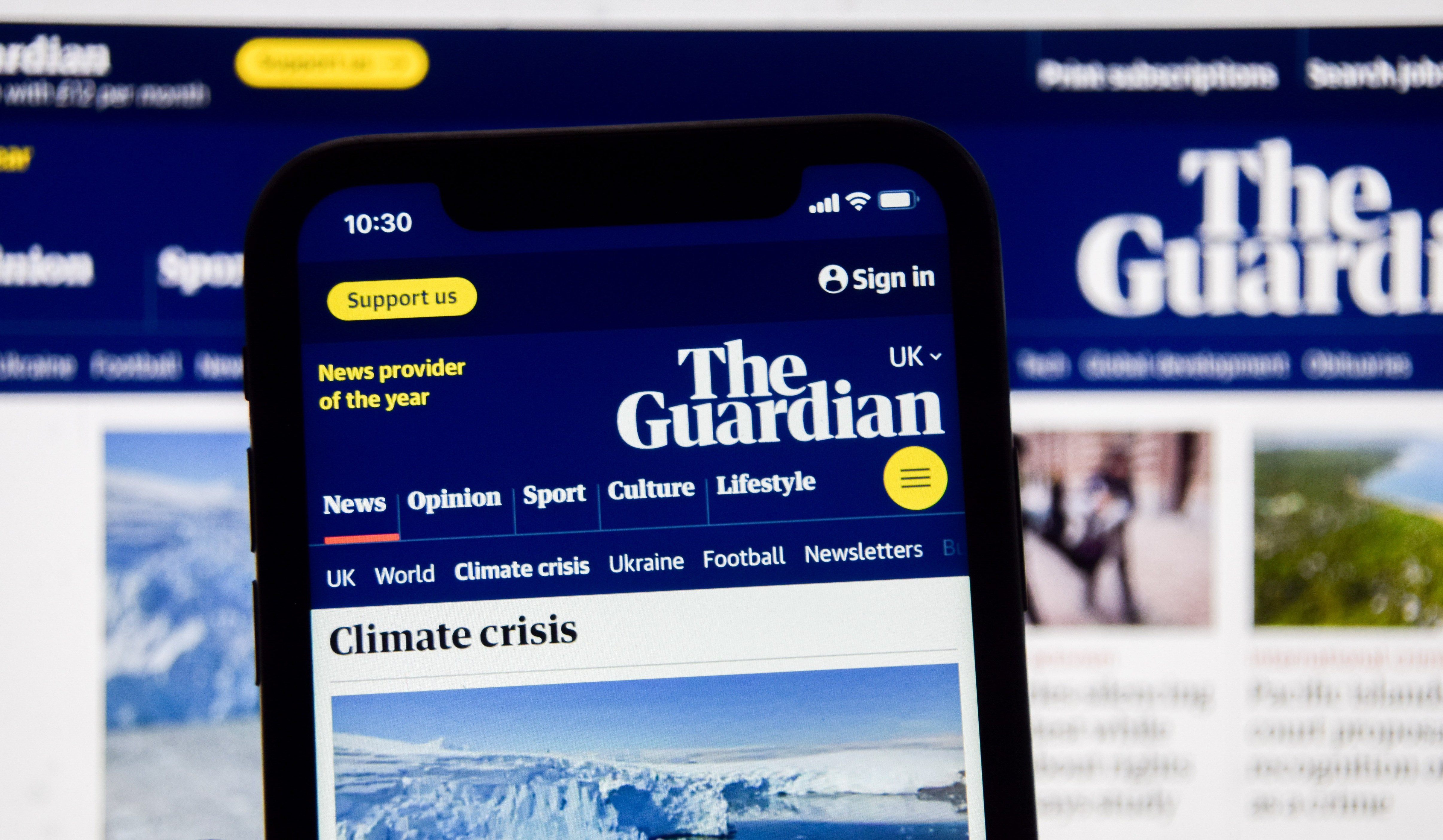 Photo illustration of The Guardian newspaper website displayed on a phone and a laptop screen.