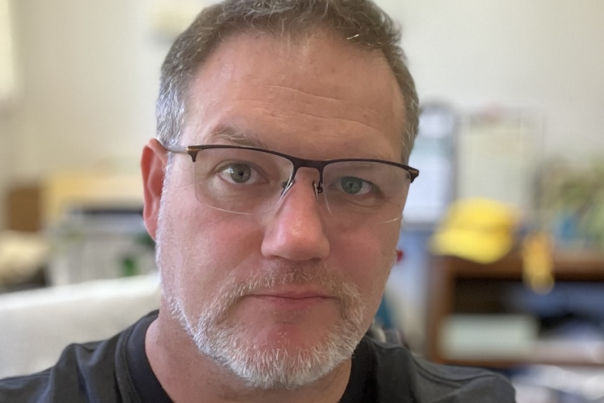 A man in glasses looking into the camera