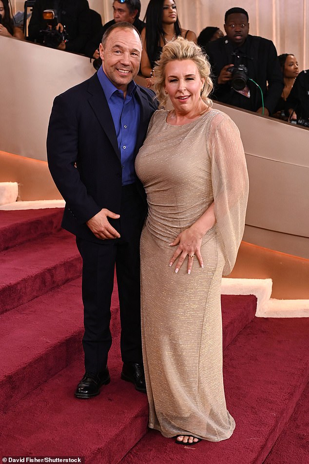 The director risked to outshine her husband as she stole the scene in a figure-hugging sand gown, with sheer bloused sleeves