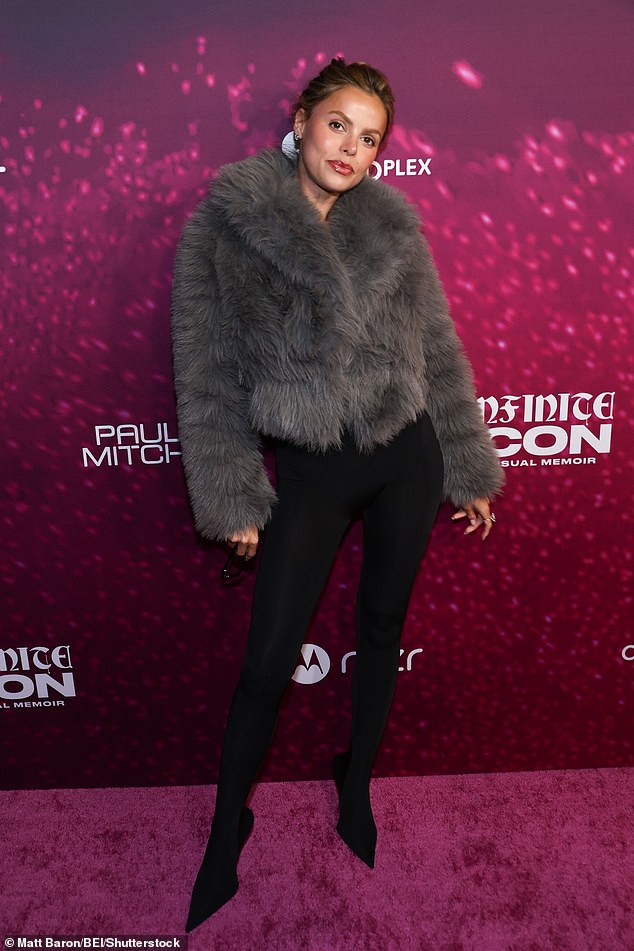 The model wore a monochromatic outfit with a dramatic, faux fur coat and added a bright pop of color with her lip gloss