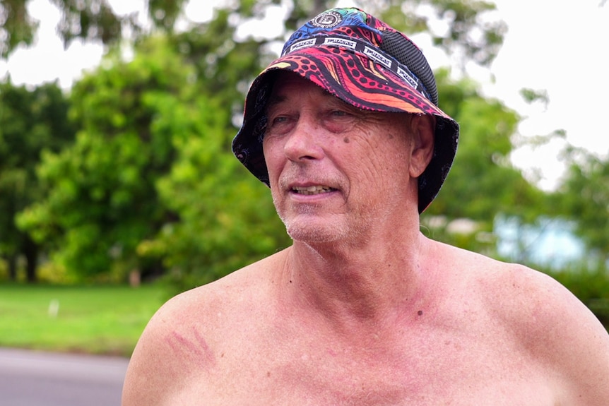 A man wearing a bucket hat pictured from the shoulders up. 