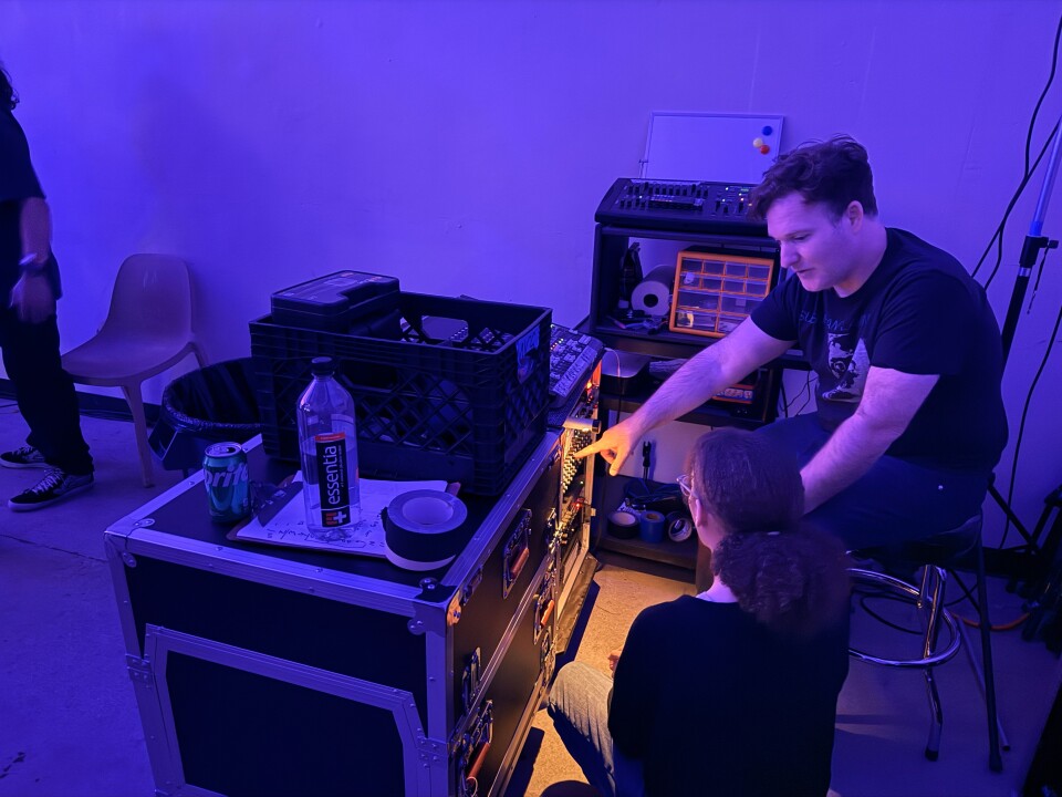 Venue operator Matt Chait sits in front of a sound mixing board. 