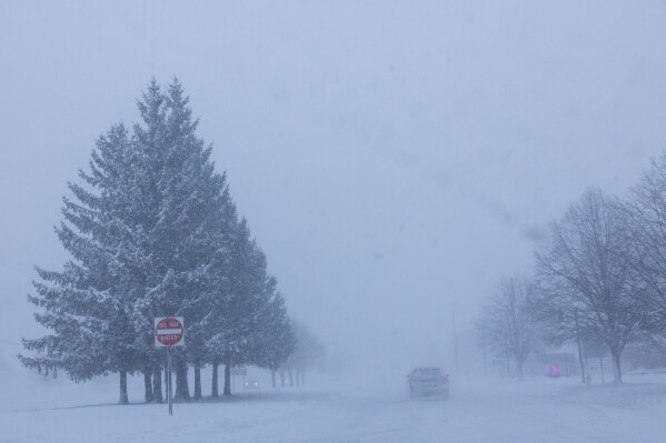 Vehicles are driven through whiteout conditions along Lake Michigan Drive during a winter storm warning in Ottawa County, Mich. on Monday, Jan. 19, 2026. (Joel Bissell/Kalamazoo Gazette via AP)