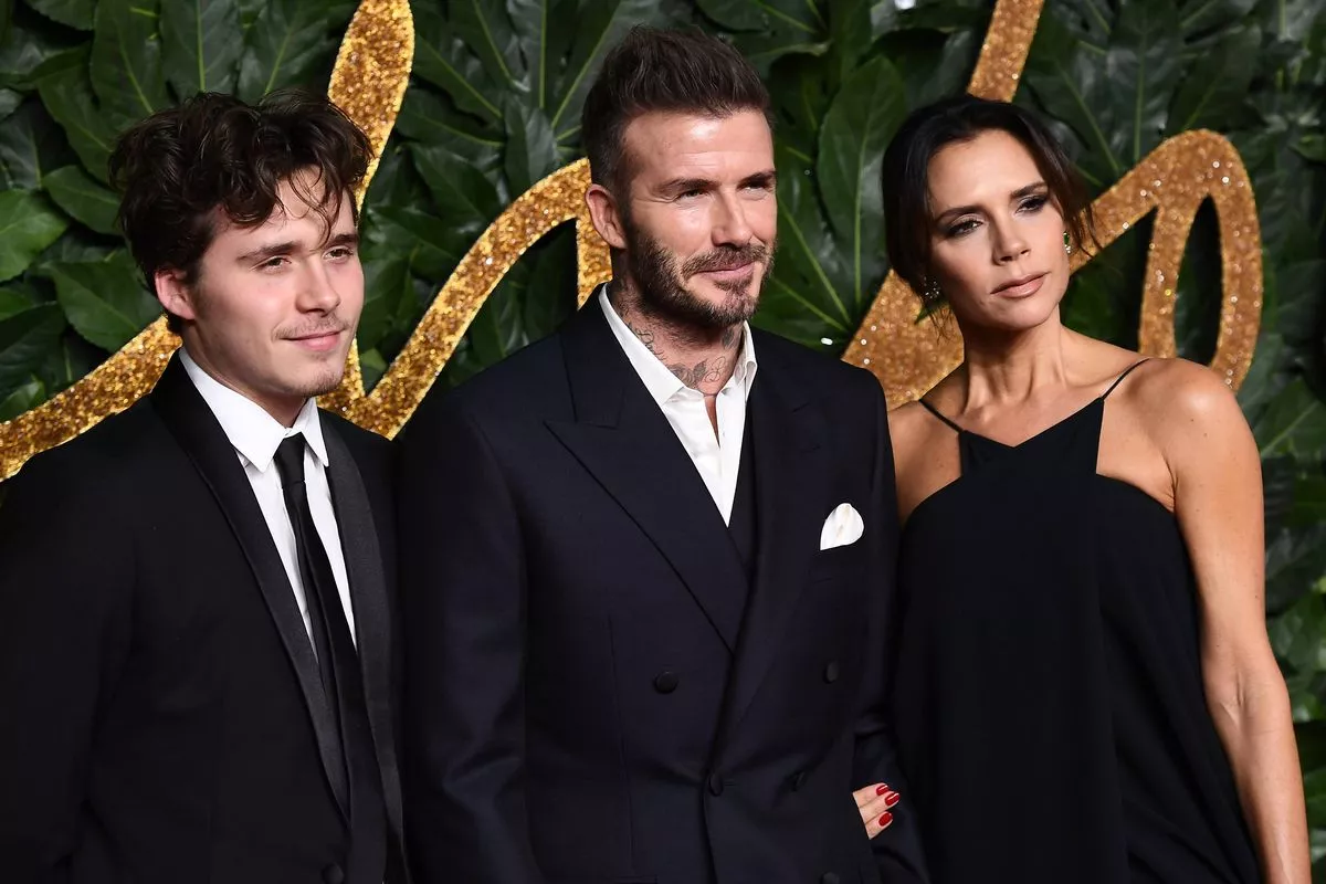 Brooklyn Beckham, David Beckham and Victoria Beckham all arrive at a fashion show.