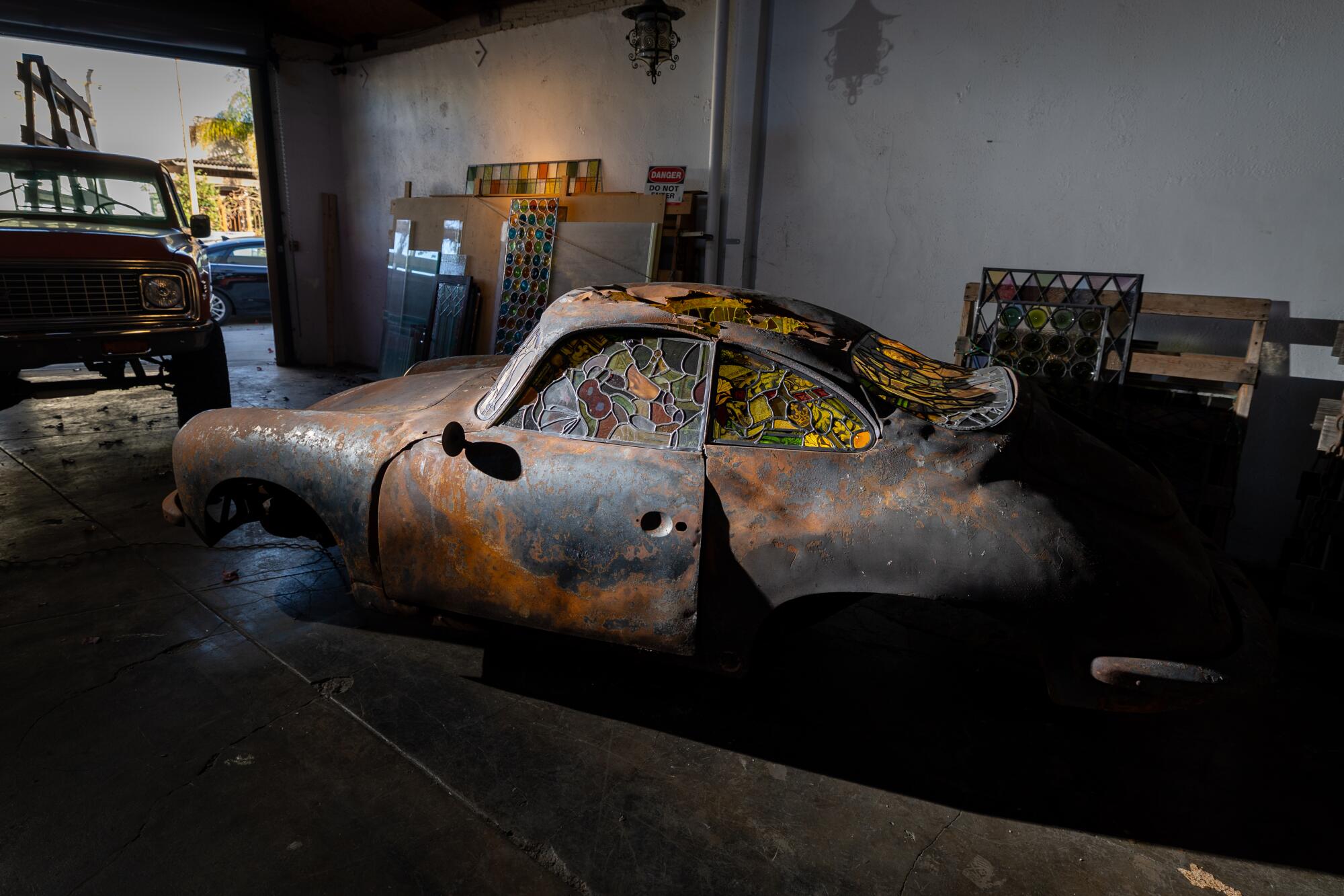A burned car fitted with stained glass windows.