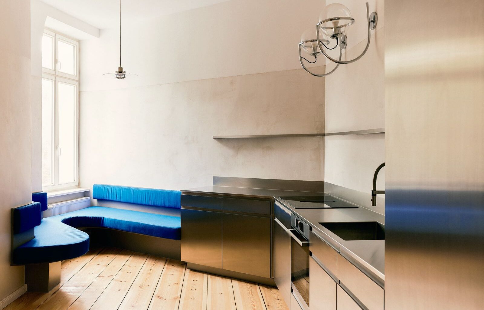 A Curvy Blue Banquette Solves a Tiny Berlin Apartment’s Puzzling Shape