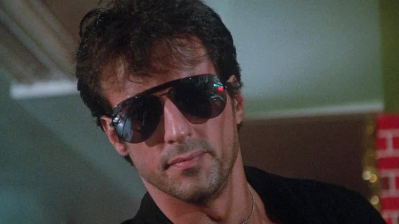 Sylvester Stallone as Marion Cobretti wearing sunglasses in Cobra
