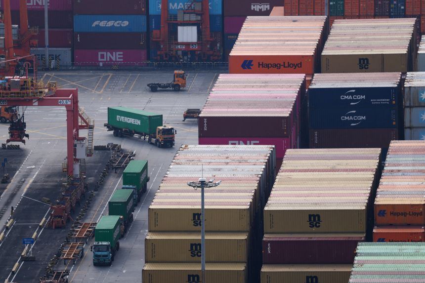 Trucks carrying containers move at a terminal of the Yantian port in Shenzhen, China, on October 30, 2025.