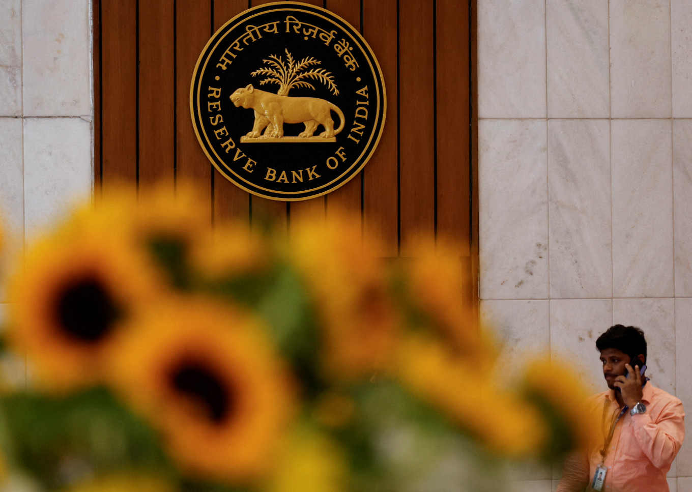 A man speaks on his phone as he walks past the Reserve Bank of India (RBI) logo inside its headquarters in Mumbai, India, on Feb. 7, 2025.