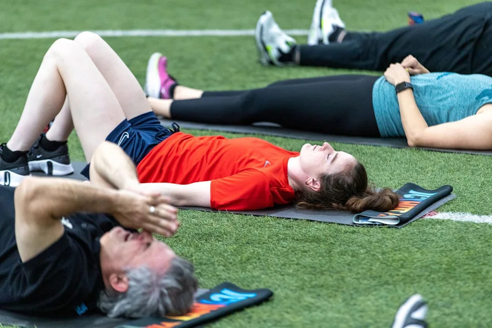 People meditate on a soccer field in May 2023 in Tukwila, Washington. Experts say mental and physical health challenges can provide similar health benefits to Dry January (Getty Images for Icy Hot)
