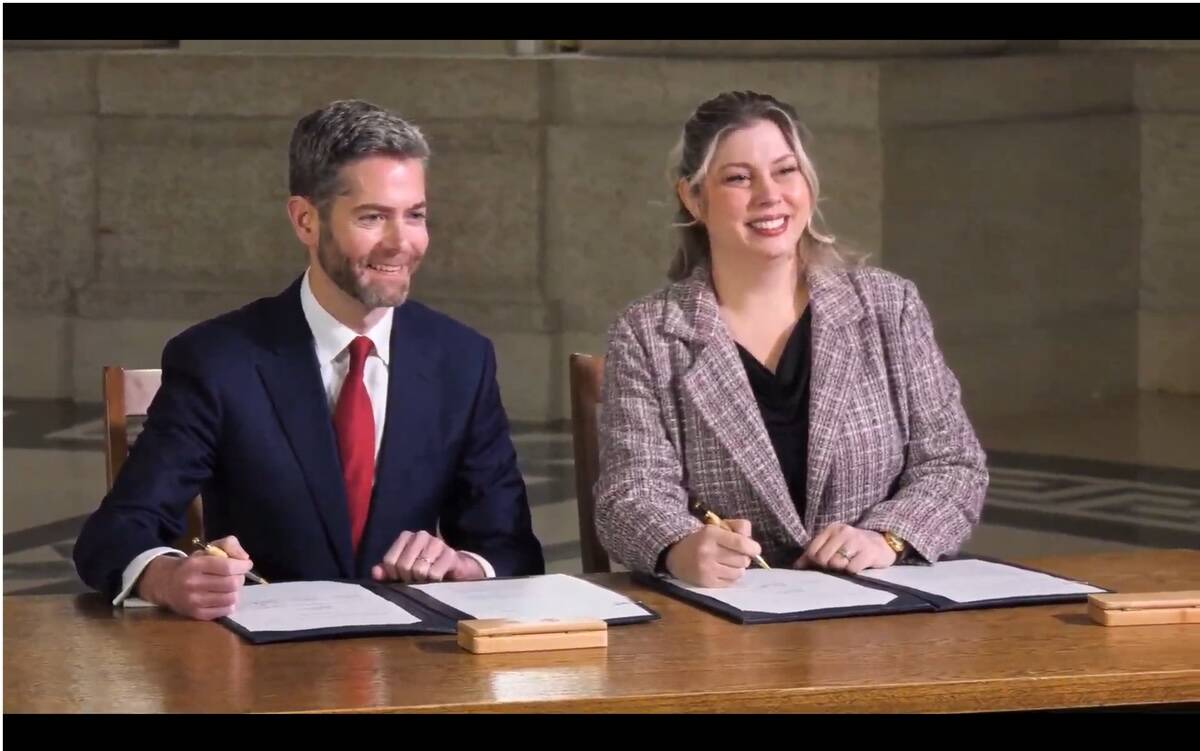 Nick Hayes, president and chief executive officer of the Winnipeg Airports Authority, and Carly Edmundson, president and chief executive officer of CentrePort Canada Inc., sign the memorandum of understanding for a Manitoba trade alliance strengthening inland, air and arctic corridors Jan. 19, 2026. Photo: Screen capture/Province of Manitoba/Government of Canada