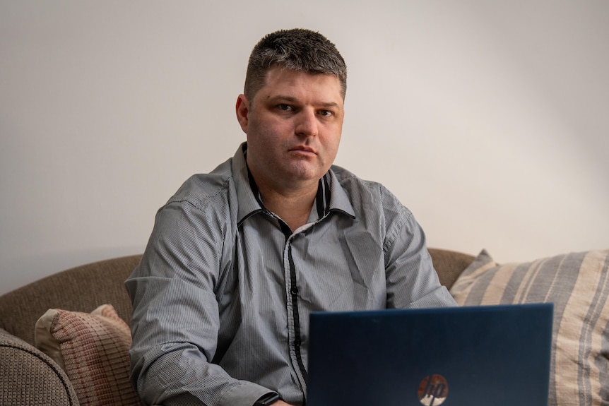 A person sitting on a couch with a computer.