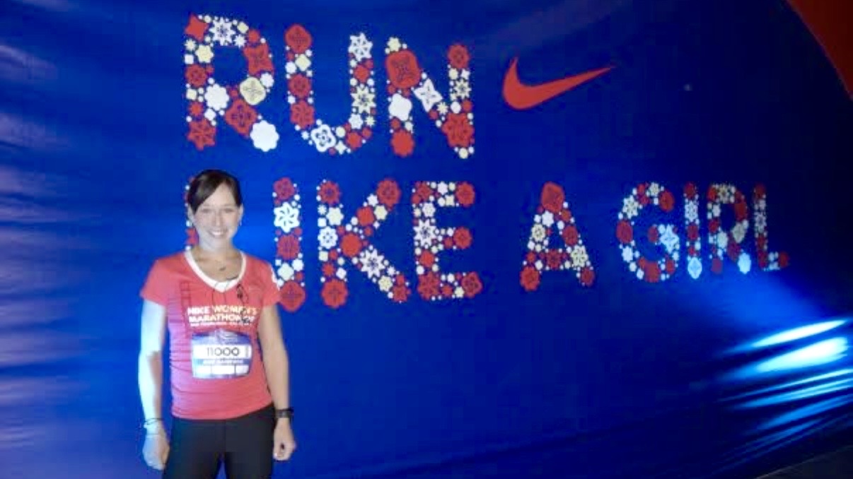 The article's author standing in front of a banner saying "Run like a girl"