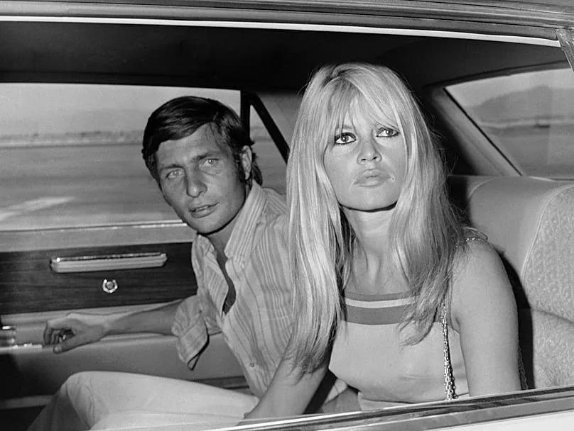 French film actress Brigitte Bardot and her husband Gunter Sachs pose just before boarding a plane on their honeymoon in Las Vegas, 14 July, 1966