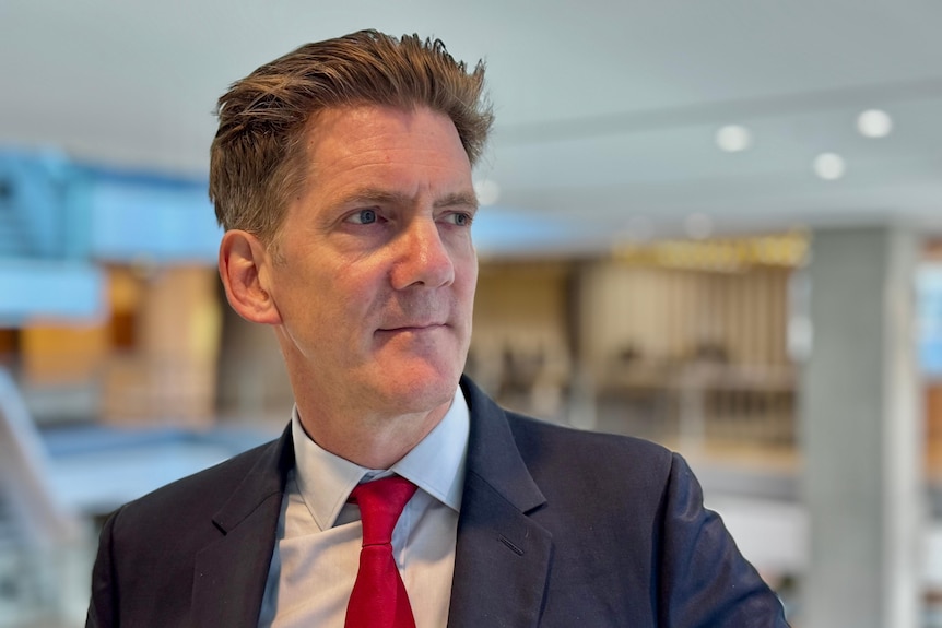 A portrait shot of Andrew Hauser wearing a suit