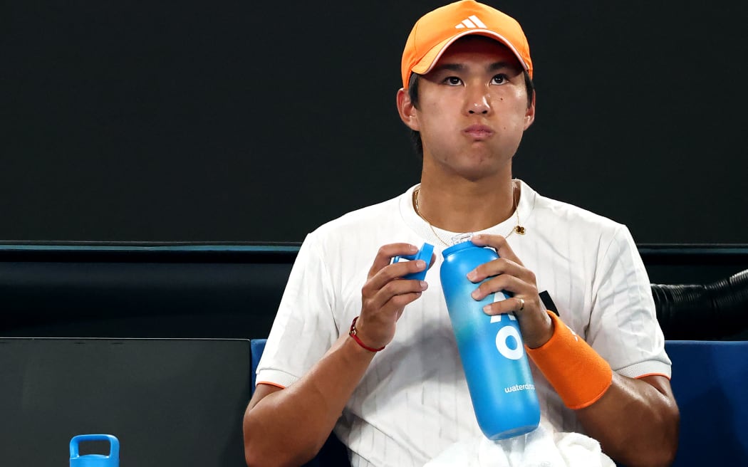 USA's Learner Tien drinks water between the games against Germany's Alexander Zverev during their men's singles quarter-final match under a close roof at the Australian Open tennis tournament in Melbourne.