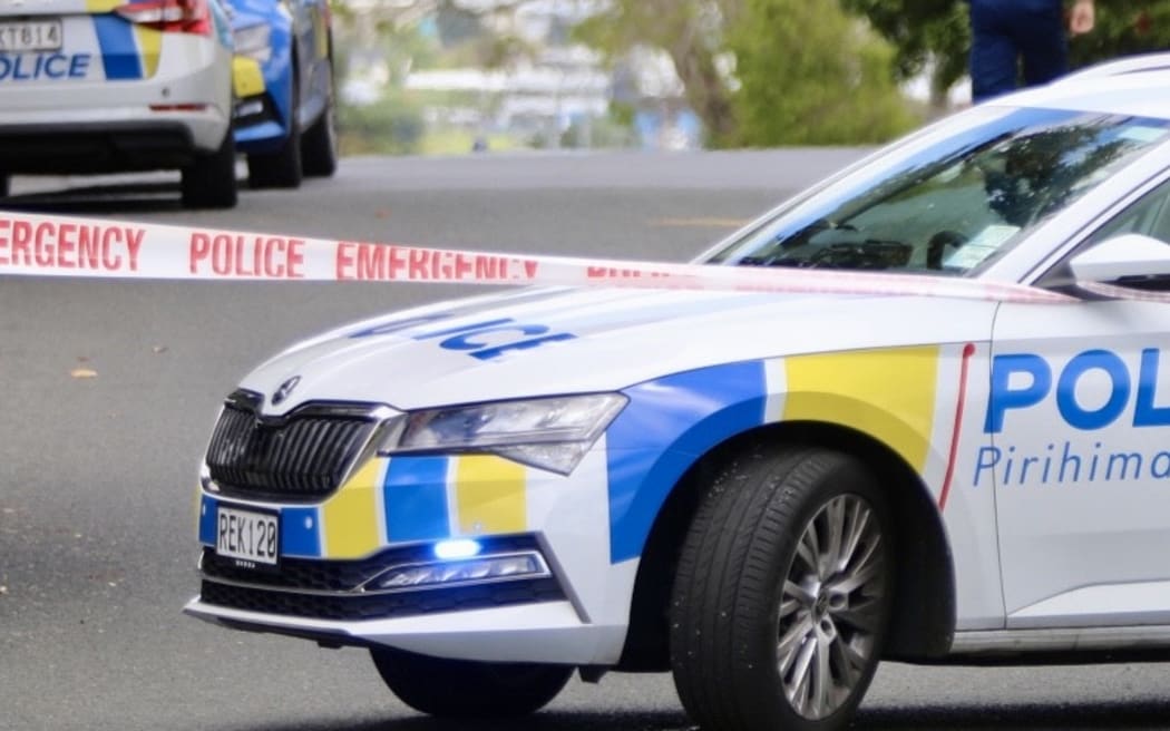 A police car seen behind a cordon as officers attend an incident.