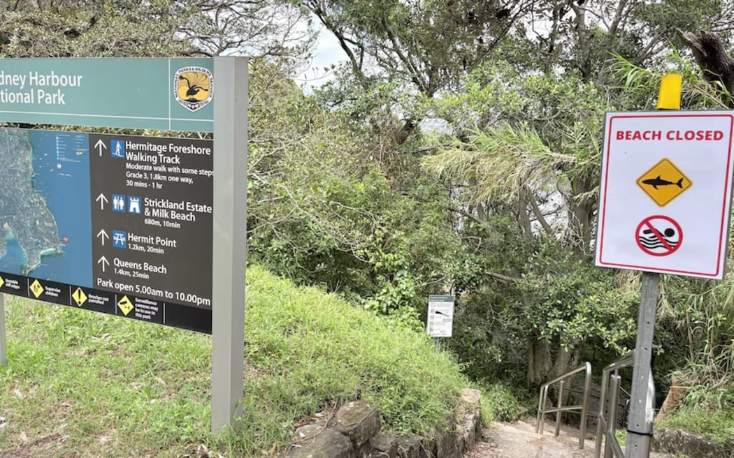 Signs reading beach closed at the entrance of a foreshore near where a boy was mauled by a shark.