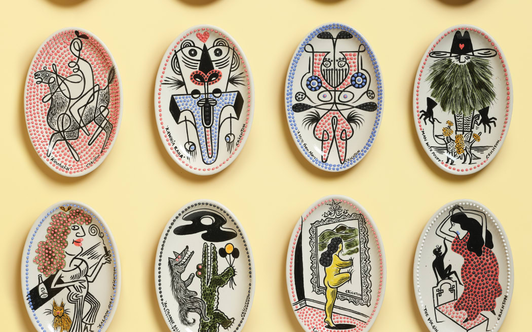 Cartoon artworks are displayed on individual ceramic creations.