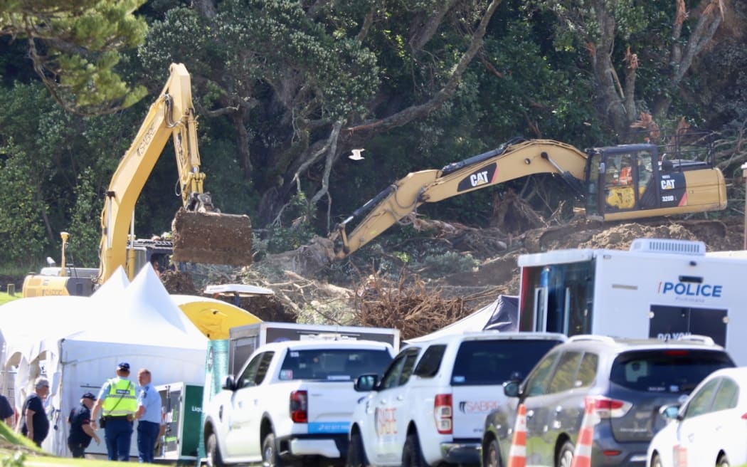Excavators have been working on moving piles of rubble while support workers on foot point out the next spot to for them to dig.