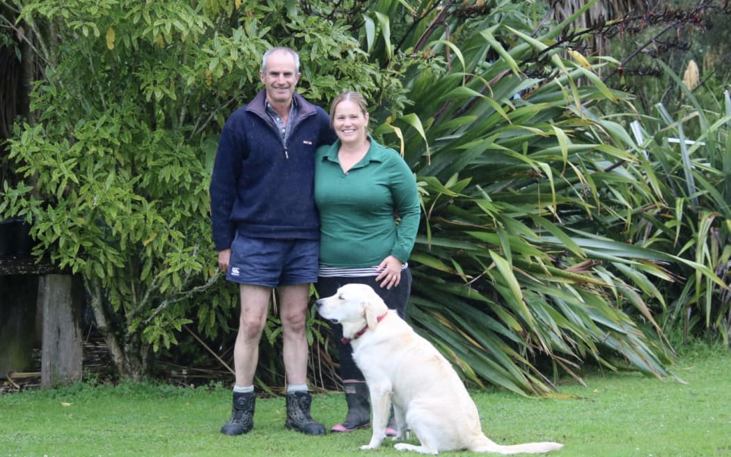 Simon and Camille McAtamney with their dog Beau. The pair say there are still thousands of trees down within forestry blocks on their property.