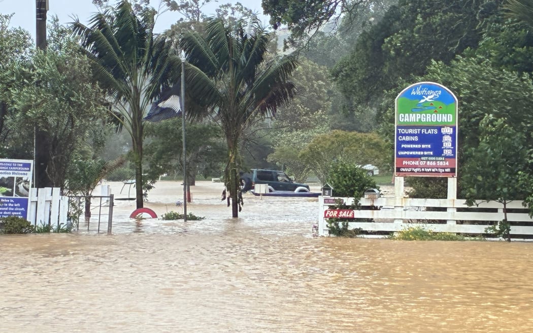 Whitianga Campground is flooded with the water halfway up the doors of vehicles.