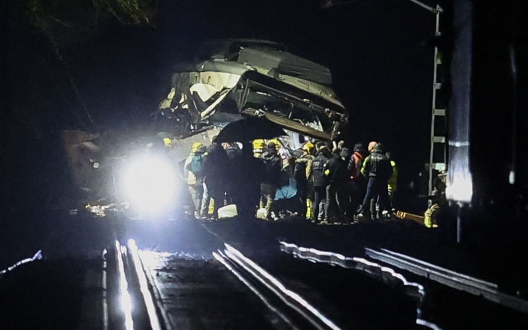 Firefighters and rescue personnel work at the site where at least one person died and four were seriously injured when a regional service train collided with a collapsed wall  between Sant Sadurni d'Anoia and Gelida, near Barcelona, early January 21, 2026. The latest incident is likely to raise more questions about Spanish rail safety after the collision of two high-speed trains in the southern region of Andalusia on Sunday killed 42 people and injured more than 120.  (Photo by Josep LAGO / AFP)