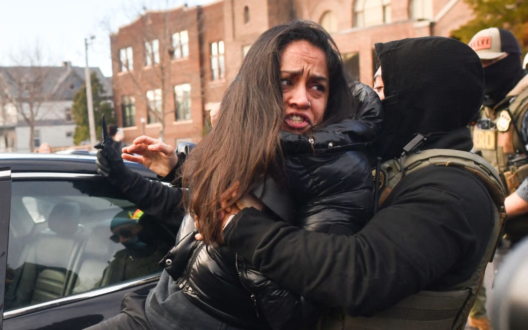ICE and other federal officers remove a woman from her vehicle near an area where ICE was operating in Minneapolis, Minnesota, on January 13, 2026. Hundreds more federal agents were heading to Minneapolis, the US homeland security chief said on January 11, brushing aside demands by the Midwestern city's Democratic leaders to leave after an immigration officer fatally shot a woman protester. In multiple TV interviews, US Homeland Secretary Kristi Noem defended the actions of the officer who shot and killed 37-year-old Renee Nicole Good, whose death has sparked renewed protests nationwide against President Donald Trump's immigration crackdown. (Photo by Octavio JONES / AFP)