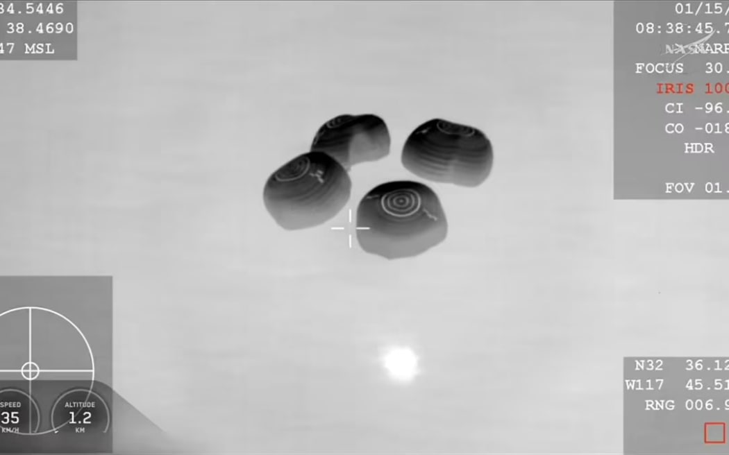 The SpaceX Dragon capsule carrying the Crew-11 astronauts is seen from a night-vision camera on board an aircraft in the moments before splashdown. NASA