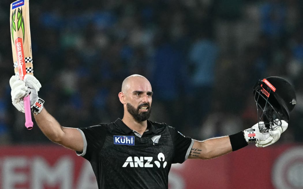 New Zealand's Daryl Mitchell celebrates after scoring a century (100 runs) during the second one-day international (ODI) cricket match between India and New Zealand at Niranjan Shah Stadium in Rajkot on January 14, 2026. (Photo by Punit PARANJPE / AFP) / -- IMAGE RESTRICTED TO EDITORIAL USE - STRICTLY NO COMMERCIAL USE --
