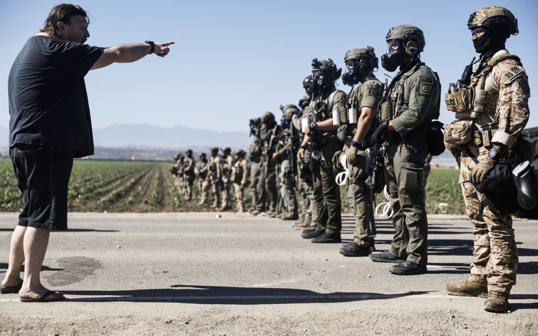CAMARILLO, CALIFORNIA - JULY 10: Federal agents block people protesting an ICE immigration raid at a nearby licensed cannabis farm on July 10, 2025 near Camarillo, California. Protestors stood off with federal agents for hours outside the farm in the farmworker community in Ventura County. A Los Angeles federal judge is set to rule Friday on a temporary restraining order which would restrict area immigration enforcement operations. Mario Tama/Getty Images/AFP (Photo by MARIO TAMA / GETTY IMAGES NORTH AMERICA / Getty Images via AFP)