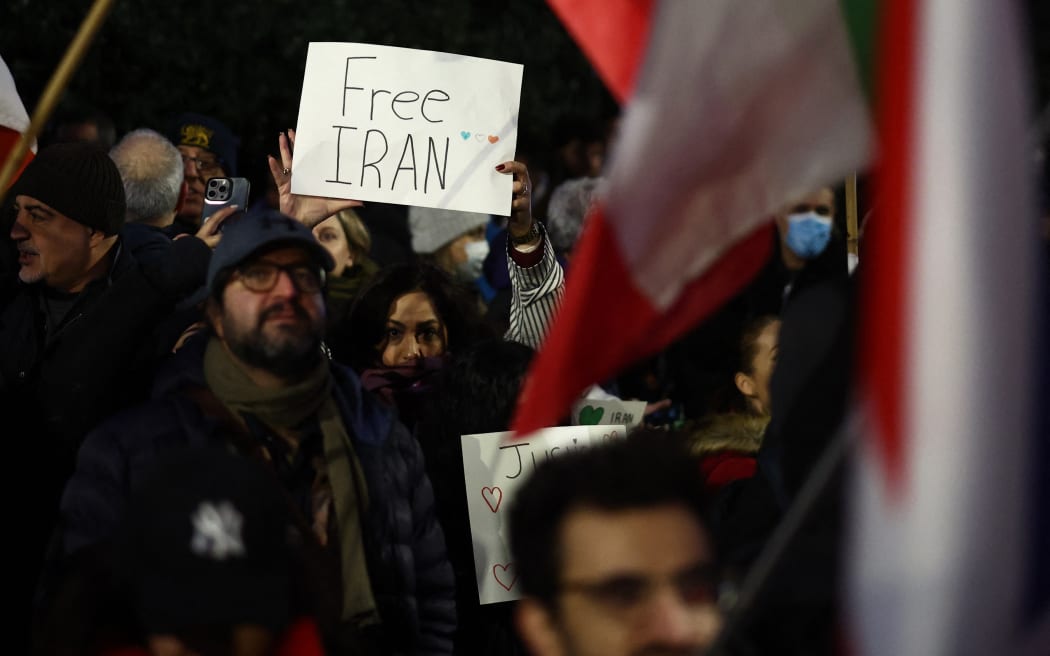 An anti-Iranian regime protester holds up a 