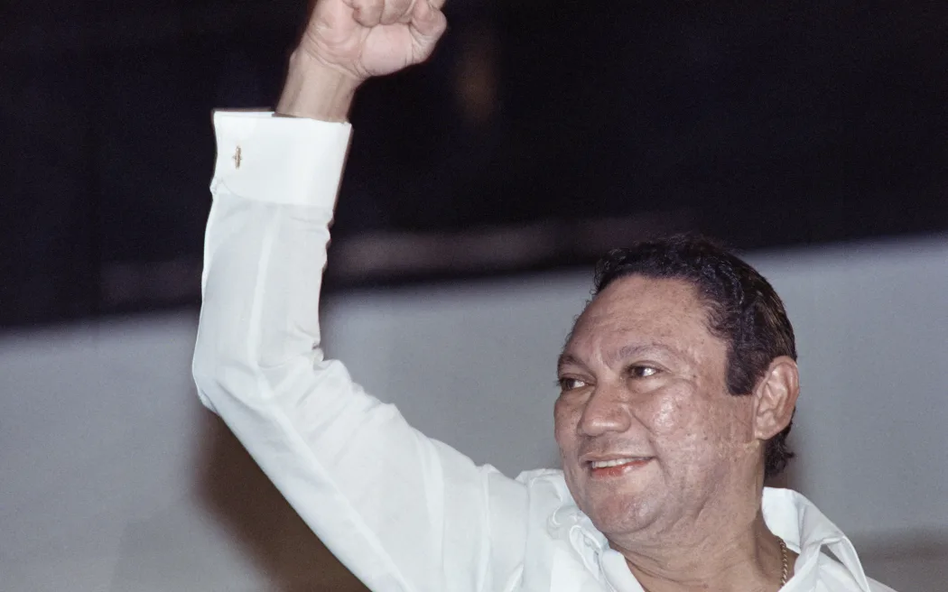 Leader of the Panamanian Defense Forces General Manuel Noriega salutes a crowd in Panama City on May 18, 1989. Noriega made his first public appearance in two weeks at a progovernment rally. (Photo by R REYNA / AFP)