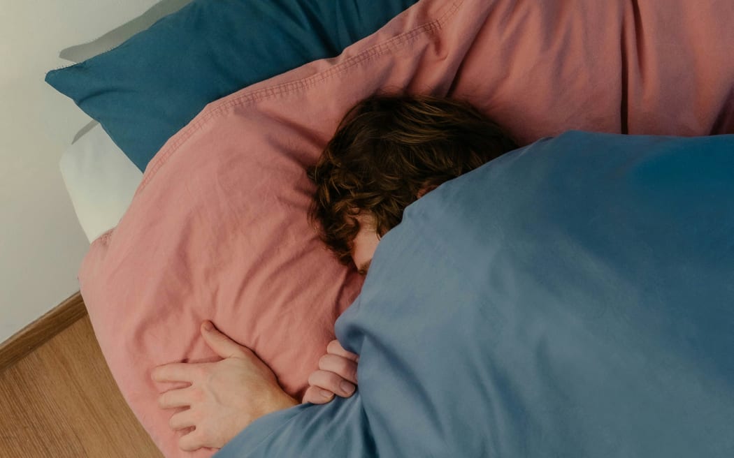 A person snuggles deeply into their pillow.