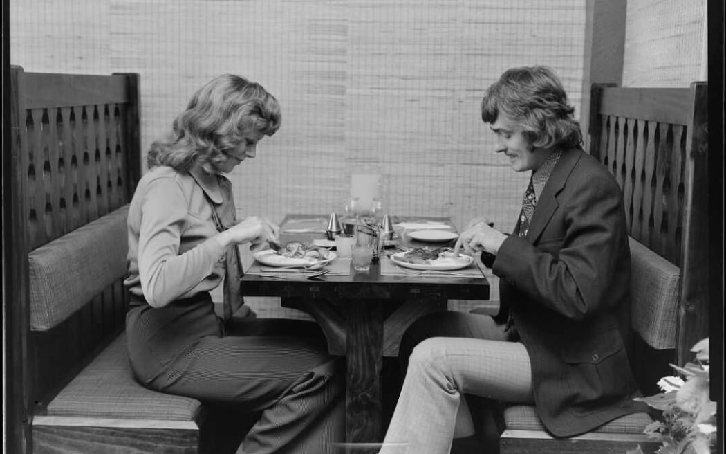 A black and white image showing a couple dining at a First Western Hotel restaurant in New Zealand in the 1970s.