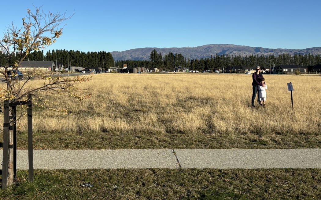 Lisa Riley and her son on the site of the proposed Super Liquor store. 