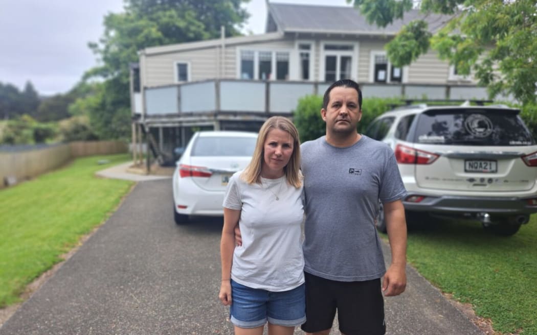 Brendon and Stephanie Deacon in front of their property that was considered category one by Auckland Council despite their neighbours all being category three following flooding.