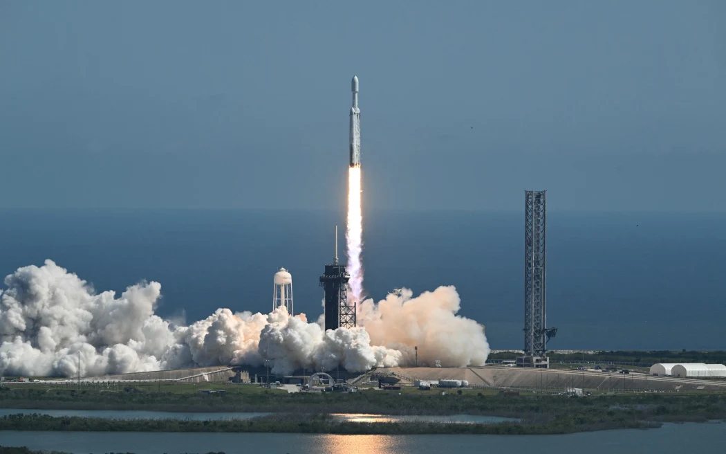 A SpaceX Falcon Heavy rocket with the Europa Clipper spacecraft aboard launches from Launch Complex 39A at NASA's Kennedy Space Centre in Cape Canaveral on October 14, 2024. The spacecraft Clipper will soon launch for Jupiter's moon Europa, one of dozens of moons orbiting the Solar System’s biggest planet and the nearest spot in our celestial neighborhood that could offer a perch for life. It should reach orbit around Jupiter and Europa in 2031, where it will begin a detailed study of the moon scientists believe is covered in frozen water, which could provide a similar habitat to Earth. (Photo by CHANDAN KHANNA / AFP)
