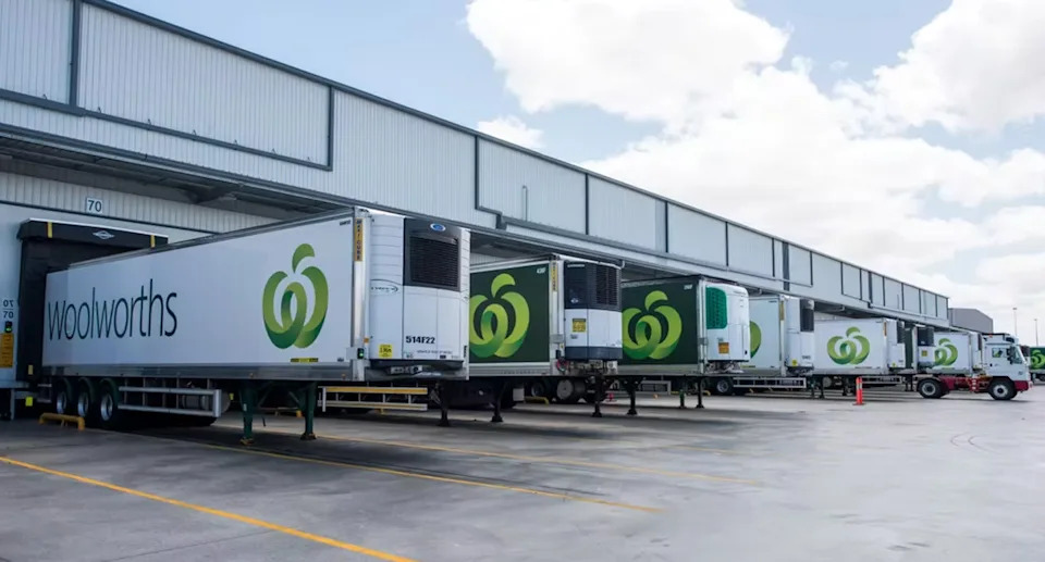 Woolworths trucks lined up outside a loading dock.