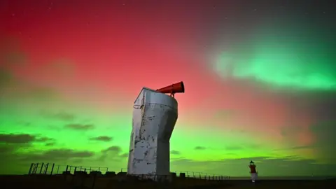 Nigel Fairclough Point of Ayre's Lighthouse, or 'The Winkie' and the Fog Horn last night amongst the Northern Lights. The sky is green and pale red.