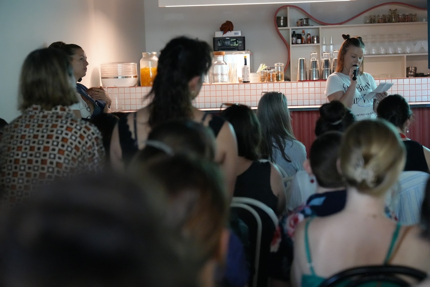 A woman speaking in front of a crowd.