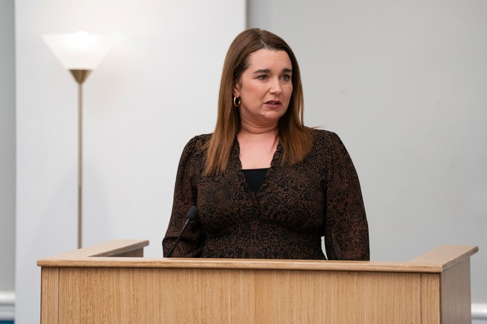 Vicki Fowler stands in a witness box in a courtroom in a scene from EastEnders