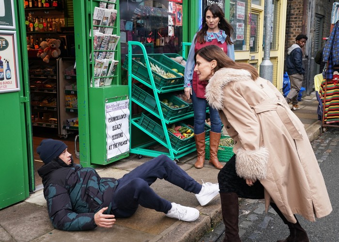 Honey watches on as Bea tackles a shoplifter to the ground in a scene from EastEnders