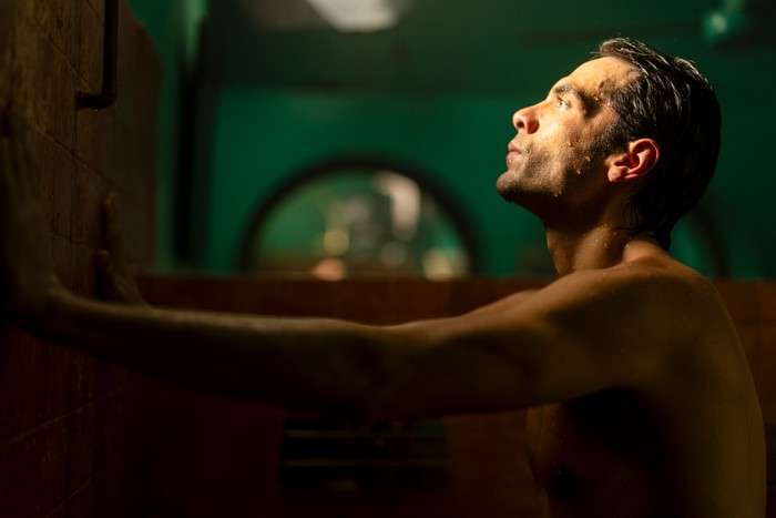 Diego Calva stars in The Night Manager season 2; in this scene, Teddy is taking a shower and looking into light shining from a high window