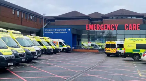 Sherwood Forest Hospitals NHS Foundation Trust A number of ambulances outside an A&E - a sign reads: EMERGENCY CARE