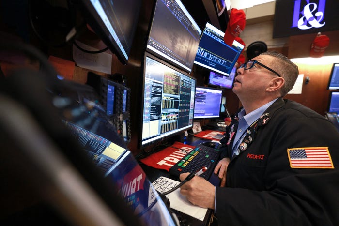 NYSE stock trader looking up at a screen at his desk