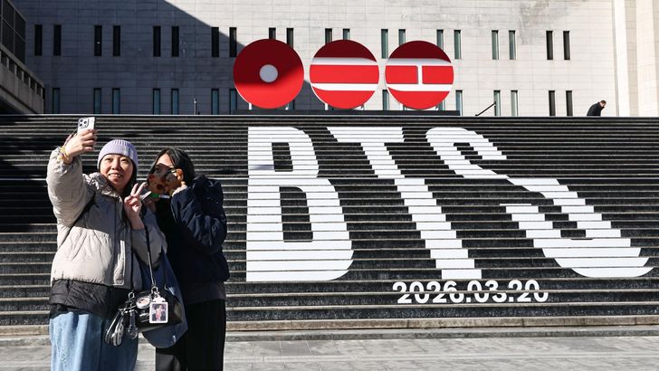 Tourists take a photo of a staircase promoting BTS' comeback in March at the Sejong Center for the Performing Arts in Seoul, Thursday. Yonhap 